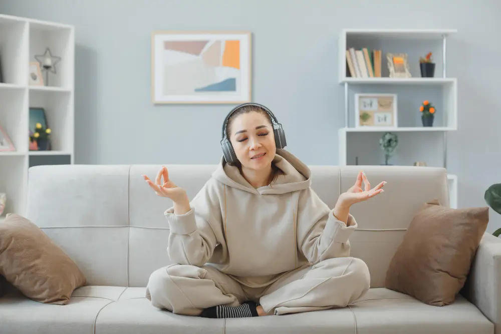 Person practicing mindfulness meditation at home, illustrating the mind-body connection between stress, emotional load, and physical comfort.