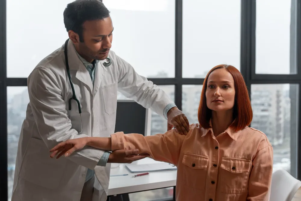 Doctor examining a patient’s arm during a consultation about chronic pain causes, symptoms, types, and when to seek medical care.