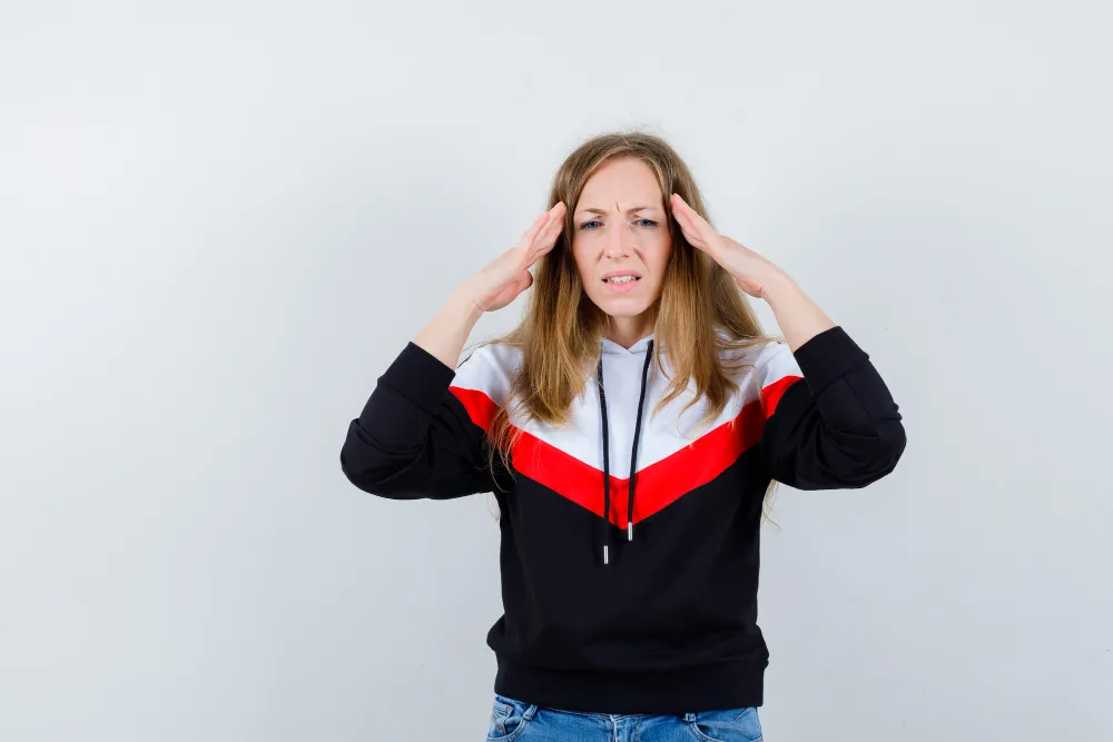 Person showing mental stress with hands on head, representing ADHD brain function, dopamine, neuroscience, and attention challenges.