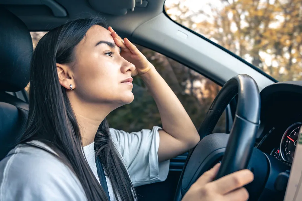 Woman driving a car while feeling stressed and focused, representing ADHD related driving challenges, road safety concerns, and licensing considerations in Australia.