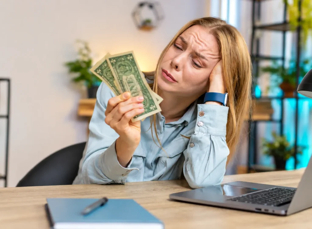 Woman with ADHD feeling overwhelmed while managing cash and finances, highlighting money challenges, budgeting difficulties, and financial stress linked to ADHD.
