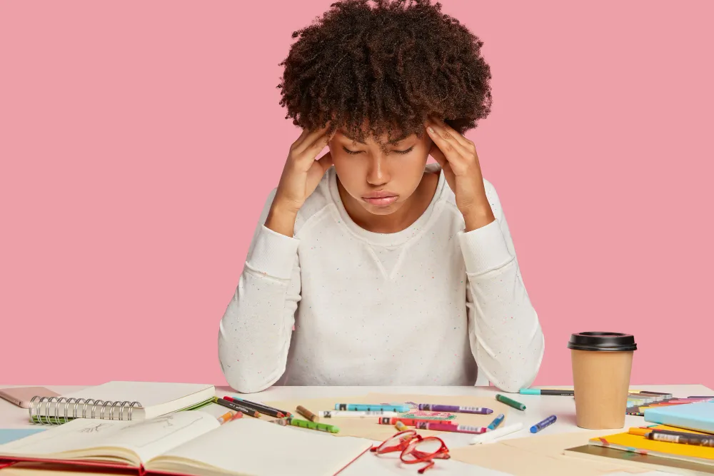 ADHD in Australia concept image showing a student experiencing difficulty concentrating while studying at a desk with books and stationery