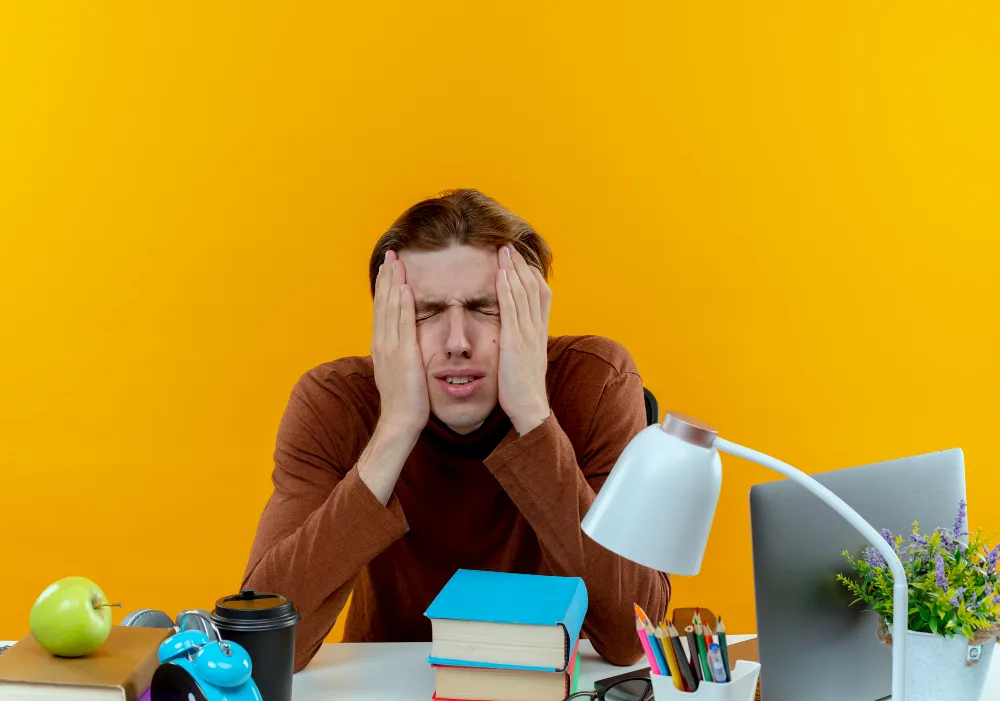 Adult with ADHD experiencing stress and difficulty focusing at a desk, illustrating the three ADHD presentations and severity levels.
